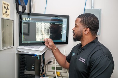 This is an image of Dr. Travis reviewing an x-ray image of the lumbar (lower back) spine.
